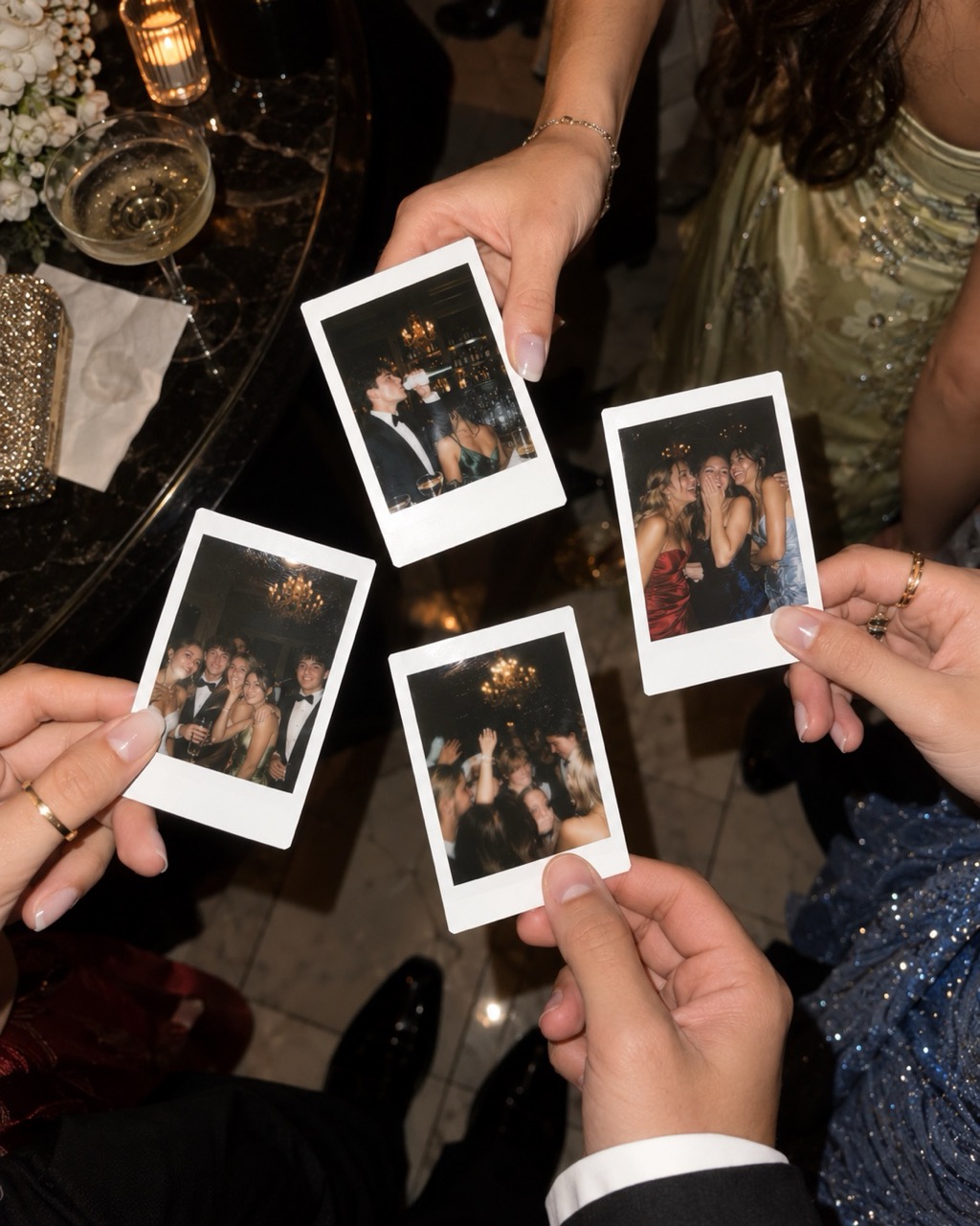 Čtyři instaxové fotky z plesu v rukou maturantů